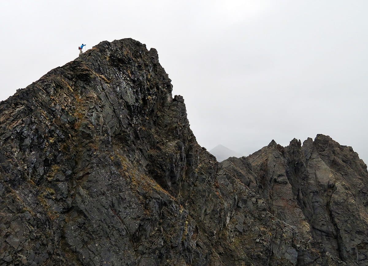 Man walking on summit of LV Ray Peak near Moose Pass, AK