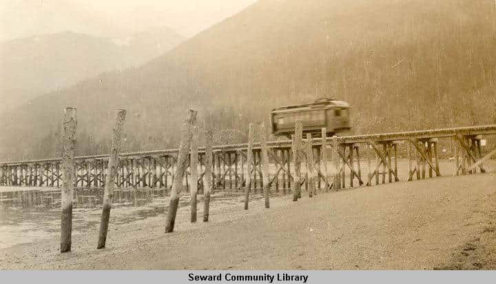 A railroad car travels on a trestle by Sylvia Sexton