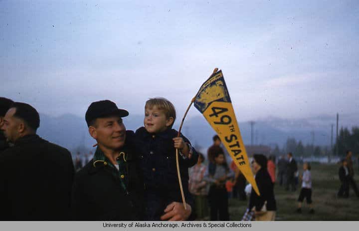 Child holding “49th State” Pennant at a statehood celebration in Anchorage in June 1958 (UAA Consortium Library – Ruth A.M. Schmidt papers, 1912-2014, UAA-HMC-0792)