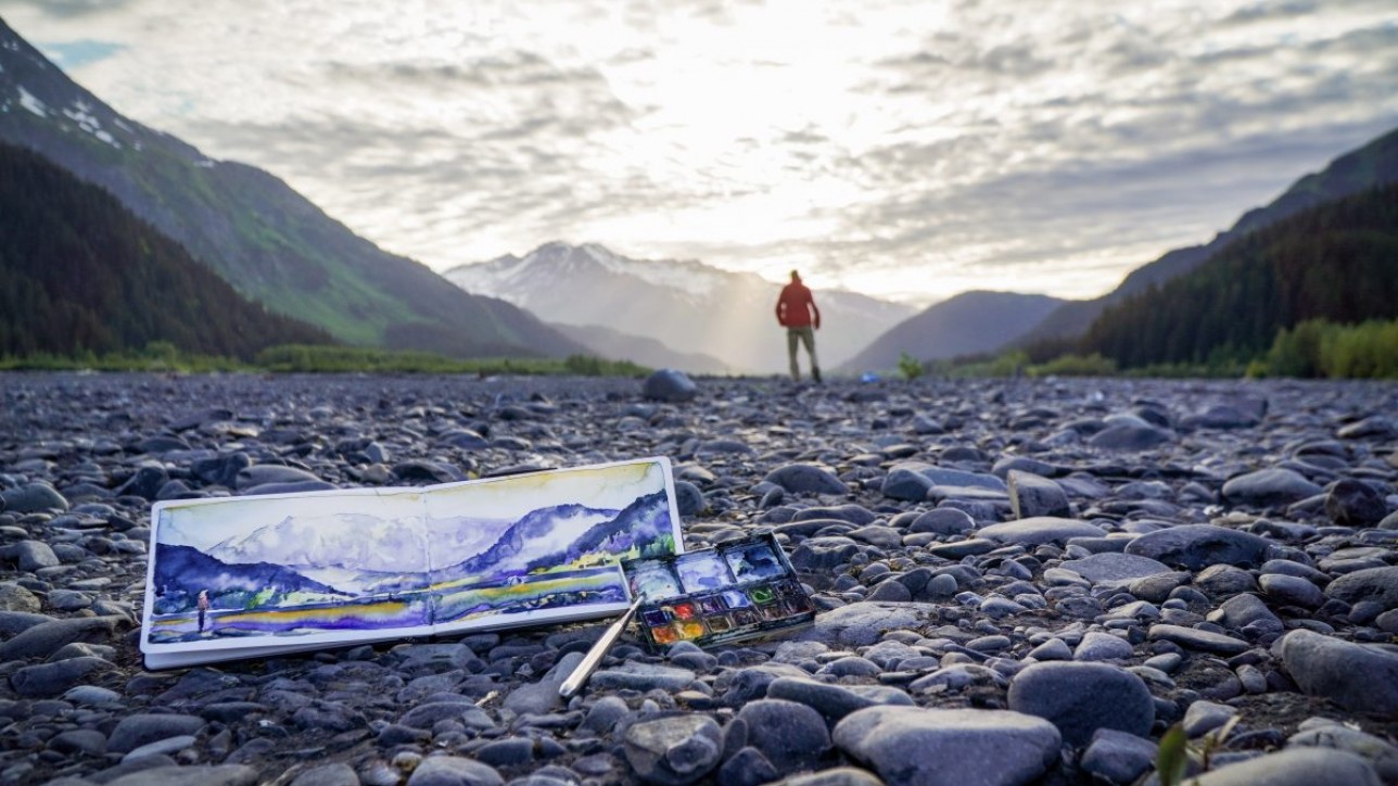 Max Romey watches as the sun begins to set in Seward, sharing a glimpse of the watercolor scene he just created.