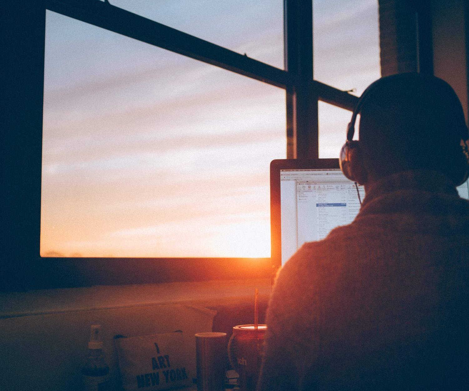 Man attending a webinar while the sun sets.