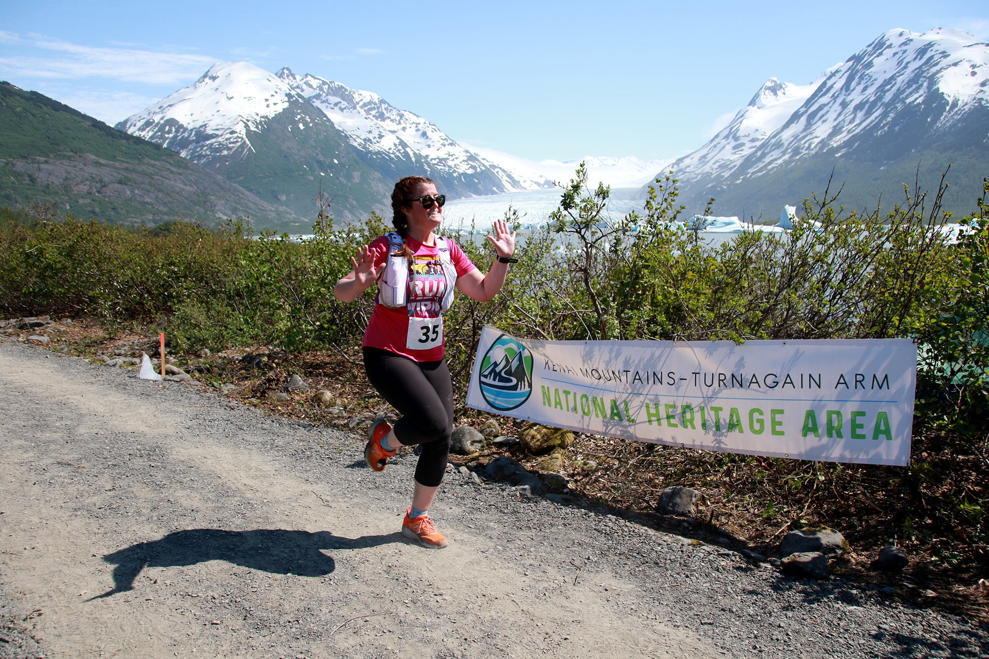 Racer runs on trail with Spencer Glacier in the background