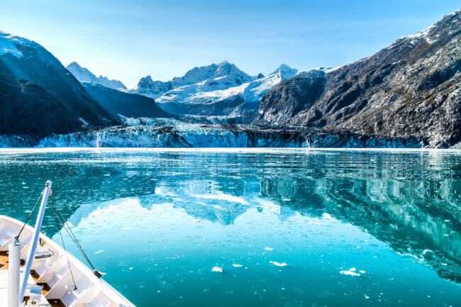 Cruise ship in Glacier Bay cruising towards Johns Hopkins Glacier in Alaska, USA. Panoramic view during summer.